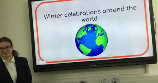 A student stood next to a board which reads 'winter celebrations around the world'