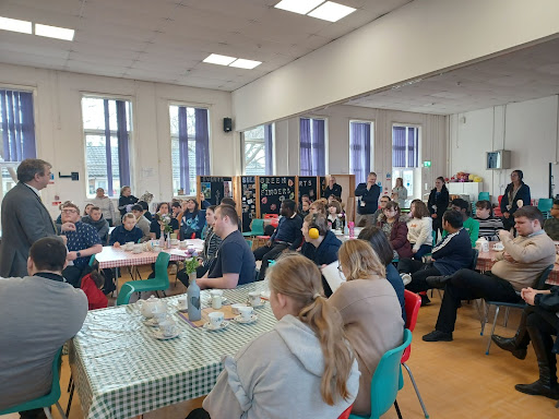 Dartford MP Gareth Johnson is pictured delivering a talk to Milestone students in a hall area.