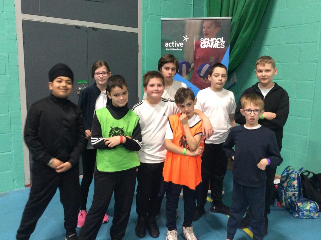 A small group of students are pictured posing for the camera together in the sports hall at The Leigh Academy, during the School Games.