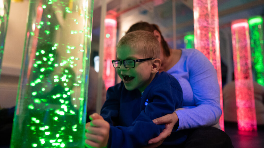 A young boy in a sensory room laughing