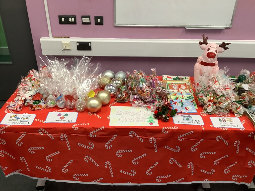 A photo of some Christmas art items that have been created by Milestone Academy students for the Phase 4 Christmas Craft Fair, spread out across a table.