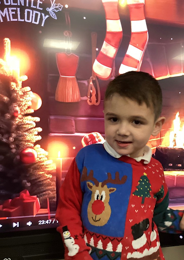 A young pupil is seen wearing his Christmas Jumper and smiling for the camera in celebration of Christmas Jumper Day 2023.