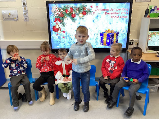 A group of six pupils are seen sat down at the front of the classroom, wearing their Christmas Jumpers in celebration of Christmas Jumper Day 2023.