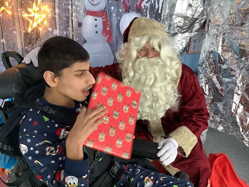 A student at Milestone Academy receives a visit from Father Christmas in his grotto and is gifted with a present.