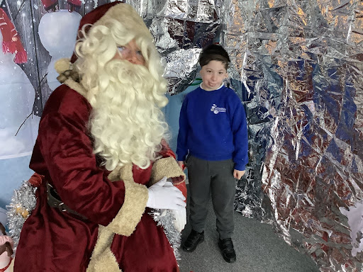 A student at Milestone Academy receives a visit from Father Christmas in his grotto.
