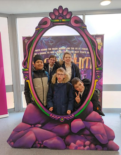 Some Milestone Academy students are seen posing for the camera through a display stand at the Woodville Halls Theatre in Gravesend after a performance of Snow White.