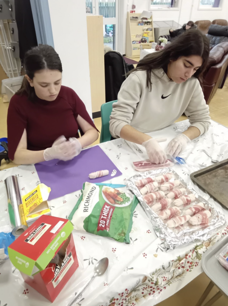 Students sat at a table preparing food for their Christmas dinner