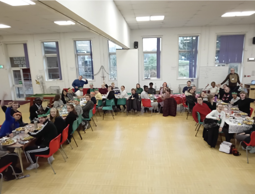 Group shot of students sat around a large table for their Christmas dinner