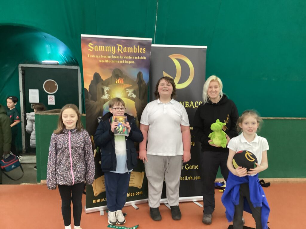 Four Milestone @ DPA students are pictured smiling for the camera, alongside the children's author, J.T. Scott, at the Kent School Games Literacy and PE Festival at Legends Sports in Gravesend, Kent.
